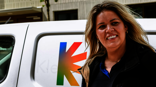 Foto van wijkbeheerder Mary voor een bus van Kleurrijk Wonen