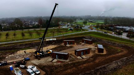 Luchtfoto van de bouw van 6 losse woningen in een cirkel met een grote kraan erbij
