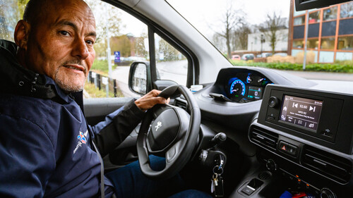 foto van wijkbeheerder Hakim achter het stuur